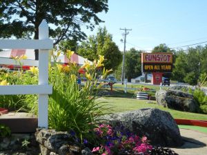 The outside of Fun Spot, its sign and green landscaping around a mini golf course.