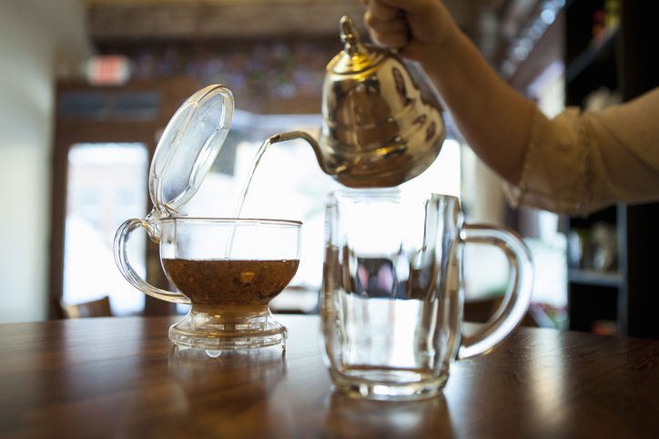 Female hand pouring tea on a tea room counter
