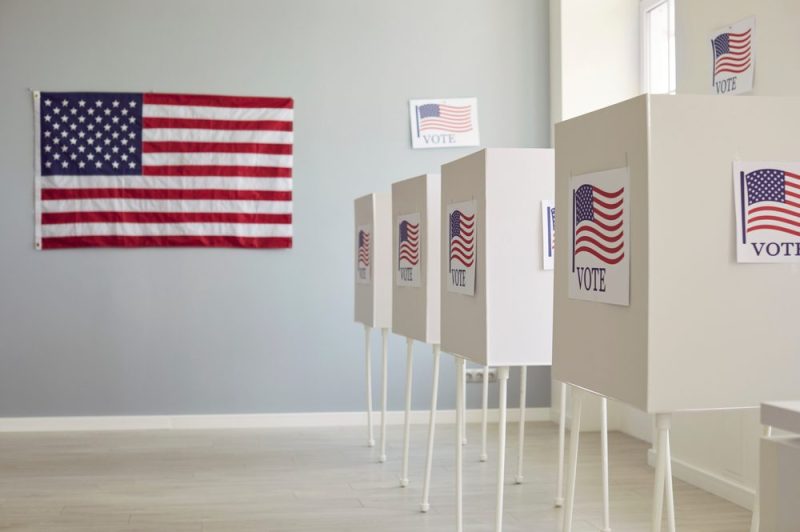 White voting booths with American flags.