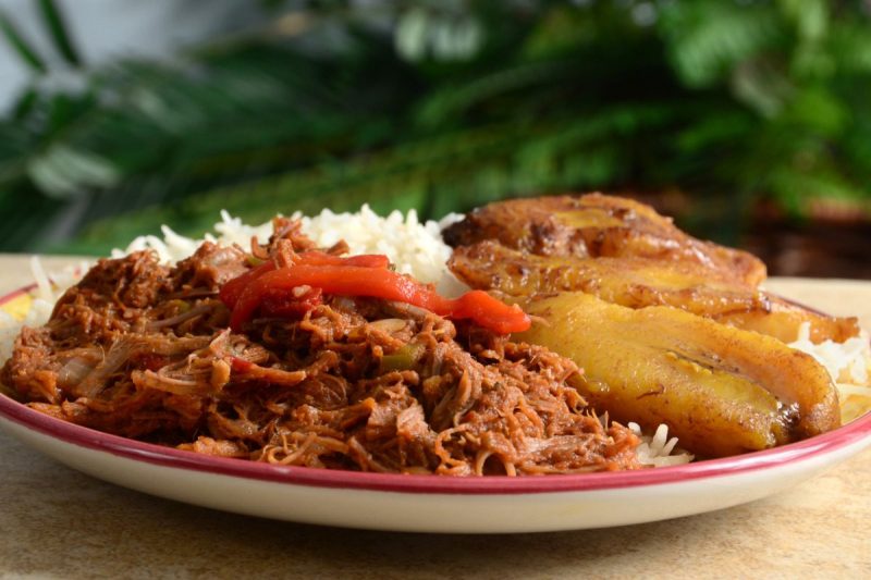 A caribbean dish with shredded beef, served with rice and fried plantains. (Via Getty Images)