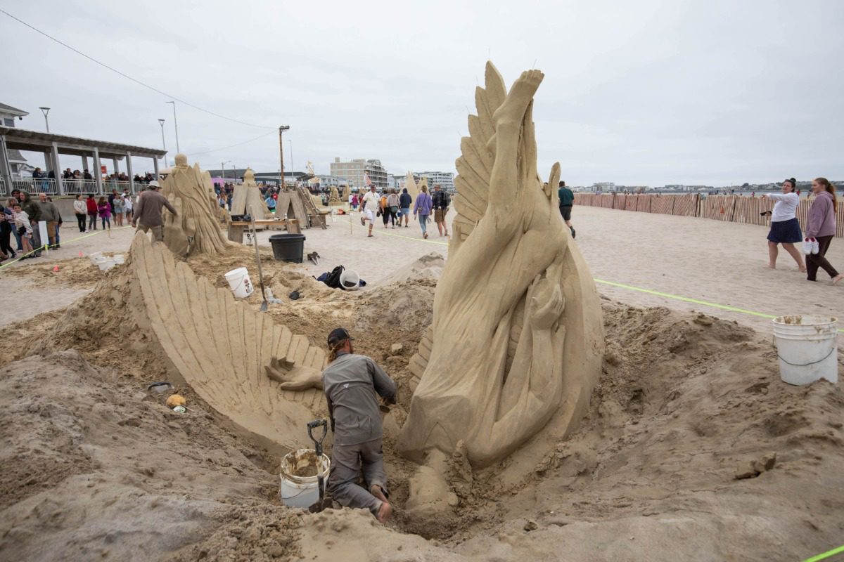 artist sculpting an elaborate piece in sand 